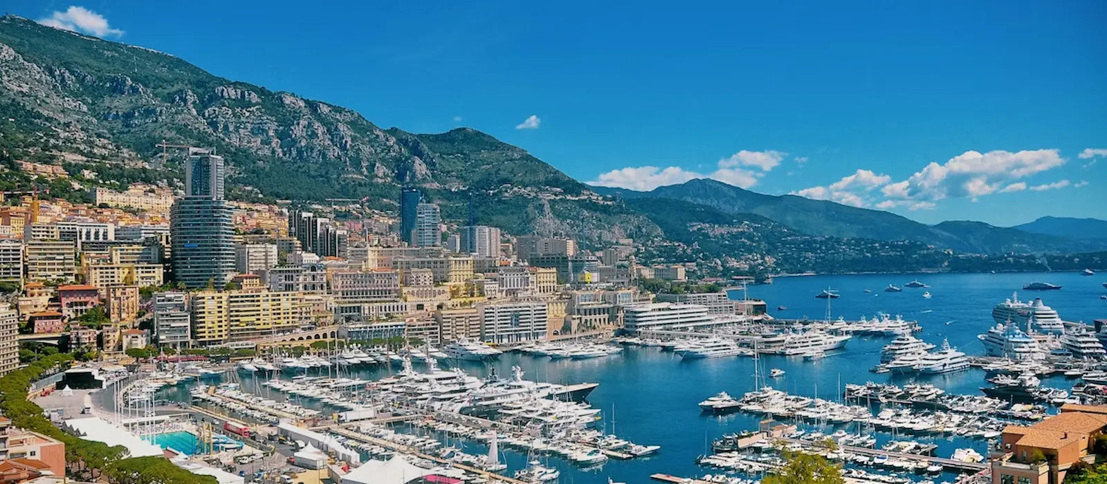 Panorama de Monaco mettant en valeur ses bâtiments emblématiques, le port de plaisance et la Méditerranée