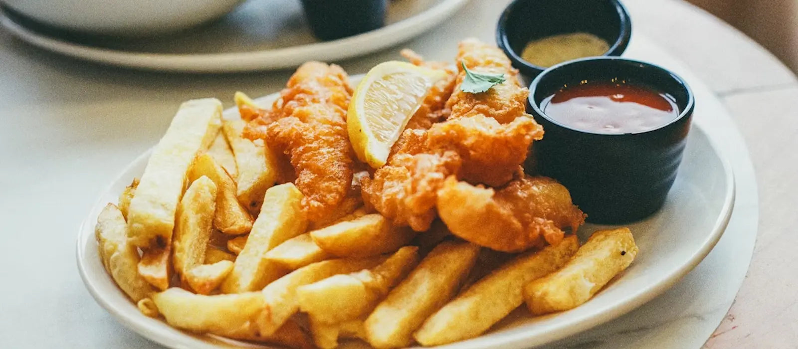 Spécialités de la gastronomie britannique présentées dans un cadre fish and ships